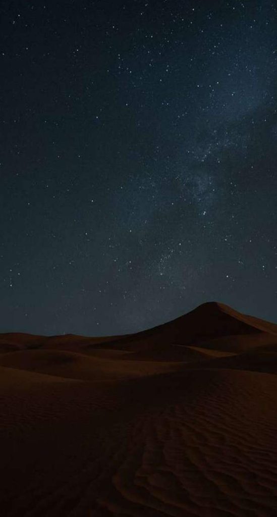 كثبان رملية تحت سماء ليلية مرصعة بالنجوم